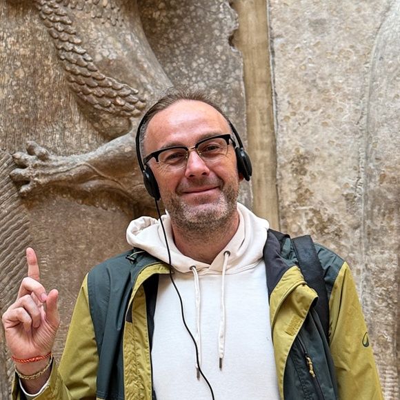 ルーヴルのCour Khorsabadで、ライオンを抱く英雄の浮彫の隣に立つArtur Jakucewicz