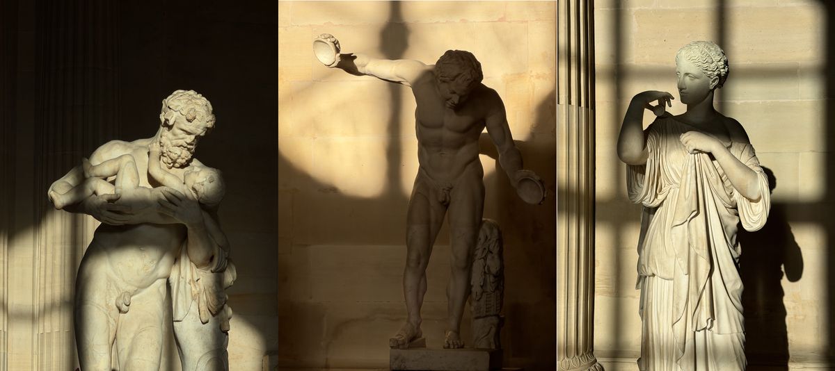 Three ancient statues in morning light in the Salle des Caryatides, including Silenus carrying the infant Dionysus and the Diana of Gabii